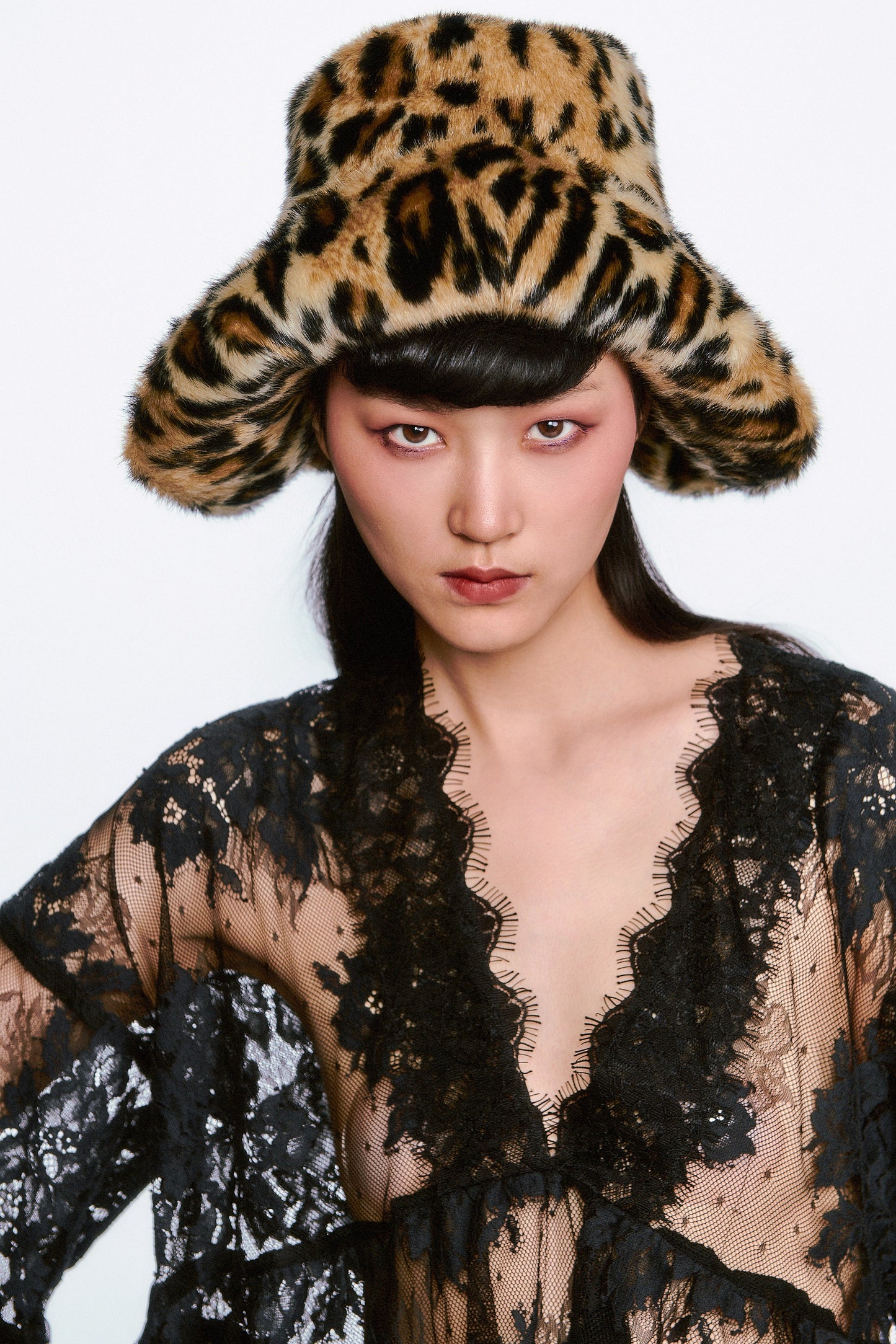 Person wearing a Faux Leopard Hat in a top hat shape and black see-thru lace garment.