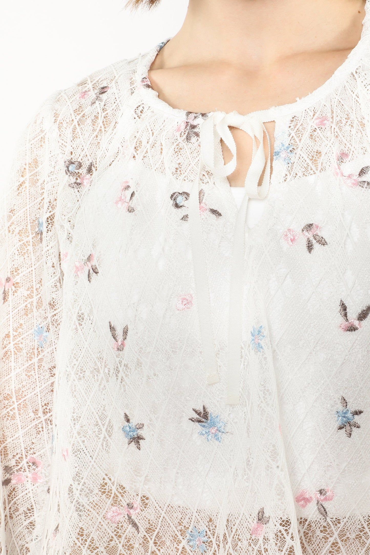 Detail on Embroidered Trellis white Blouse, with the diamonds pattern and the ribbon at the collar