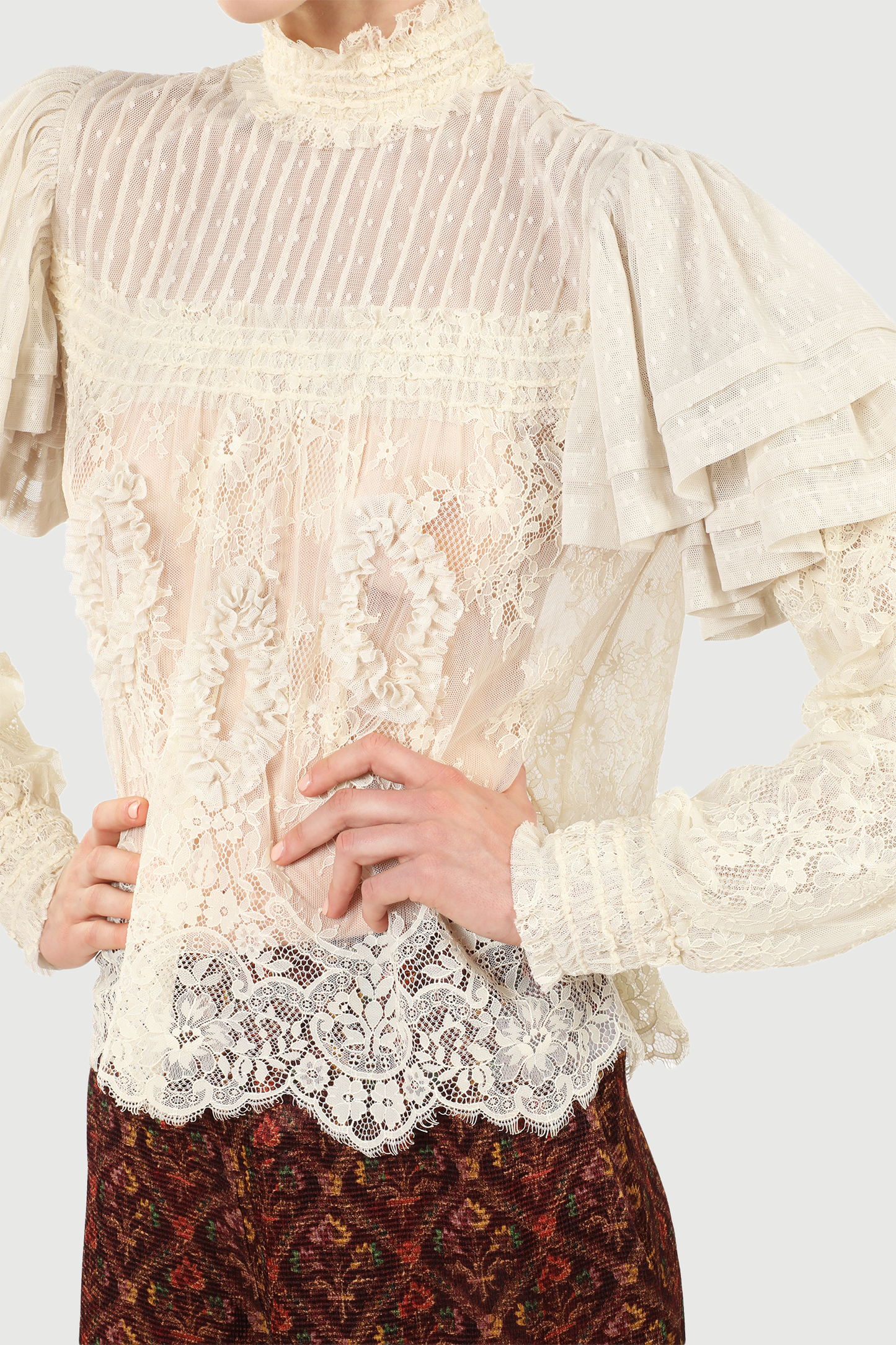 Close-up of a person wearing a Victorian Lace Blouse cream with long sleeves, ruffles at shoulders .