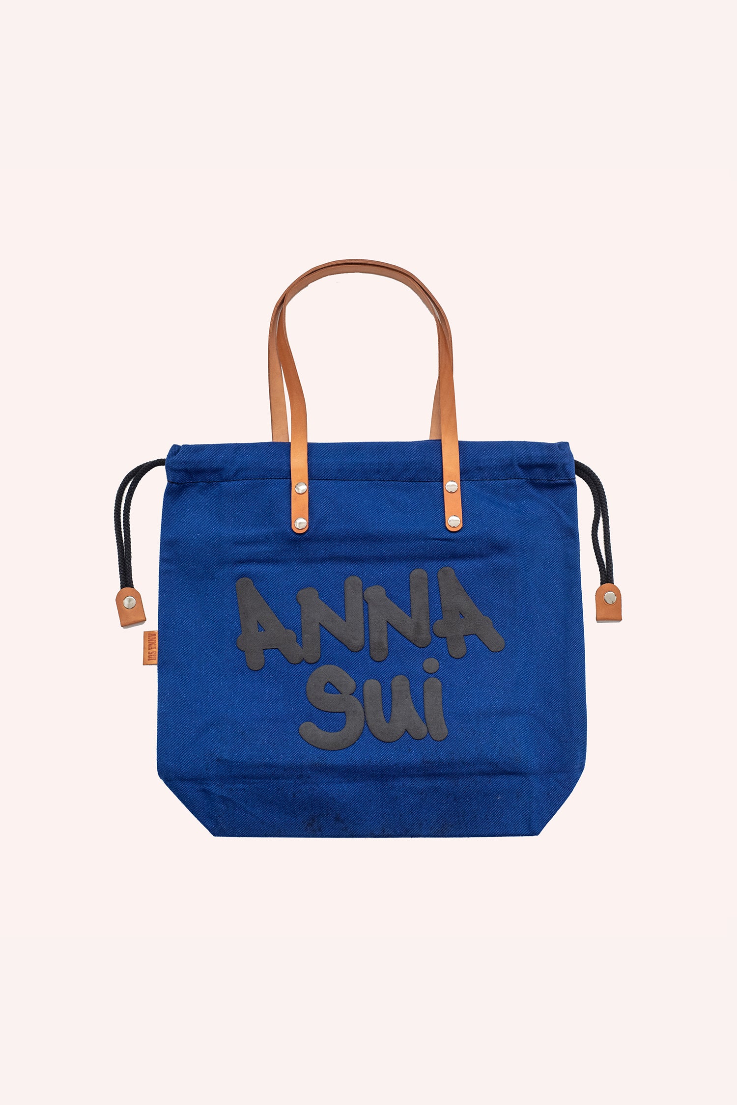 Tote bag, navy squared shape, brown handles, black laces to closed, Anna Sui label in large font