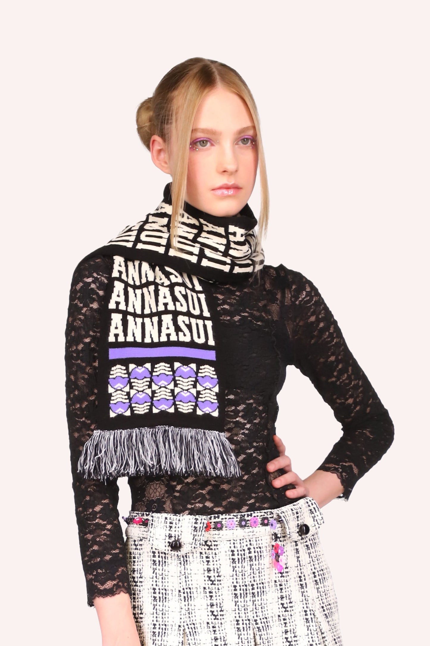Pattern Anna Sui label, with purple fringes, a stylized egg design under, a purple line on both ends
