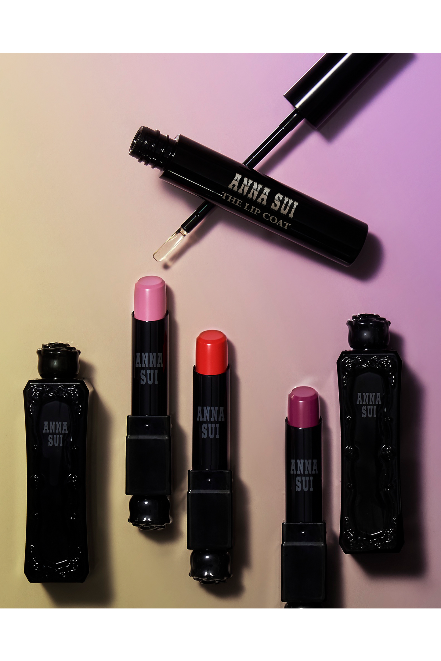Presentation of Lip coat, in a black cylindrical container, with white label Anna Sui, the Lip Coat