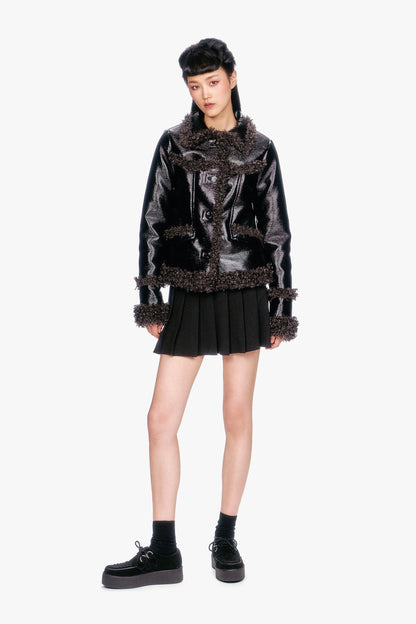 Person wearing a Faux Leather W/Curly Lamb Trim Jacket with black mini skirt, socks and shoes