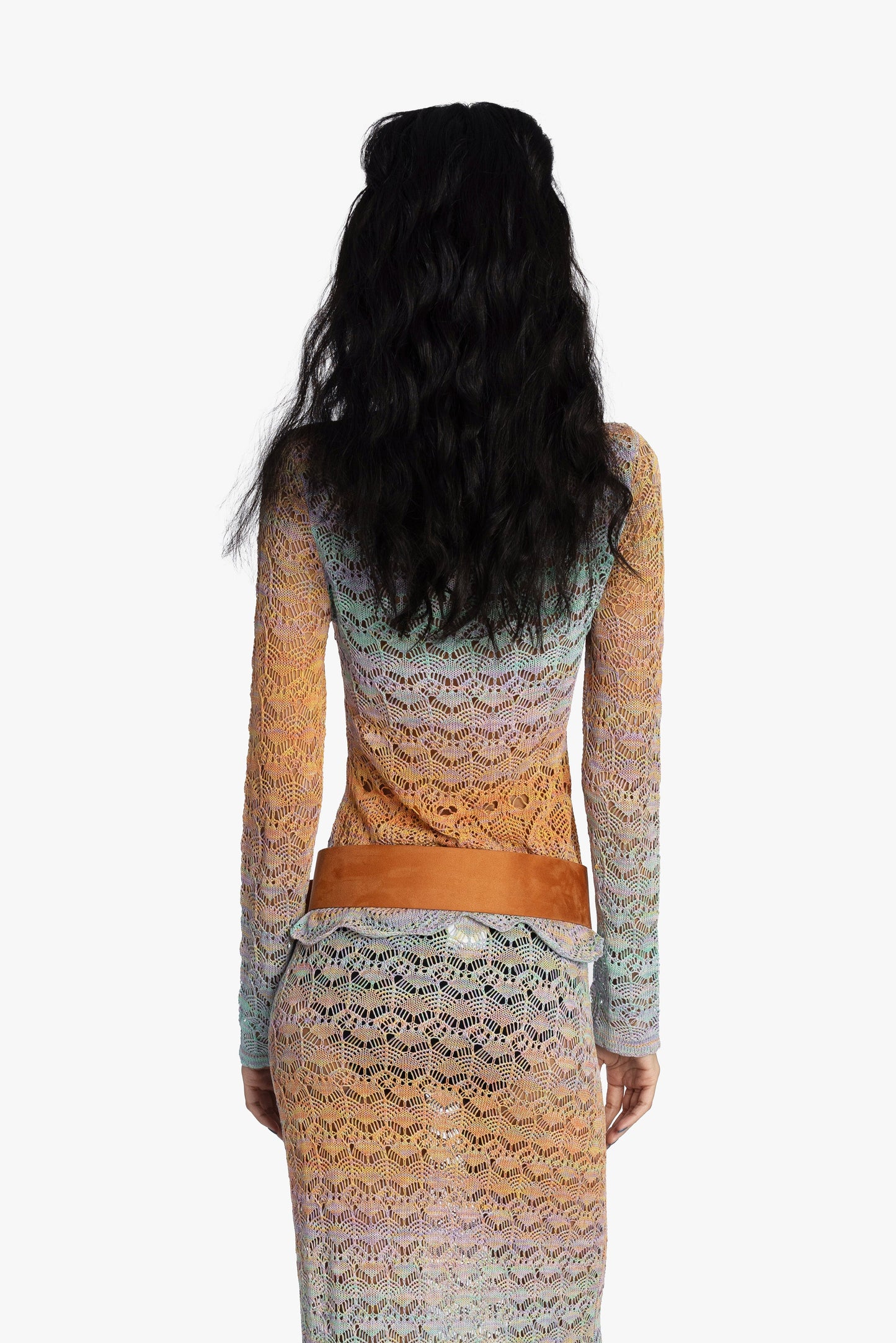 Back view of woman wearing a gradient crochet top with belt on a white background.