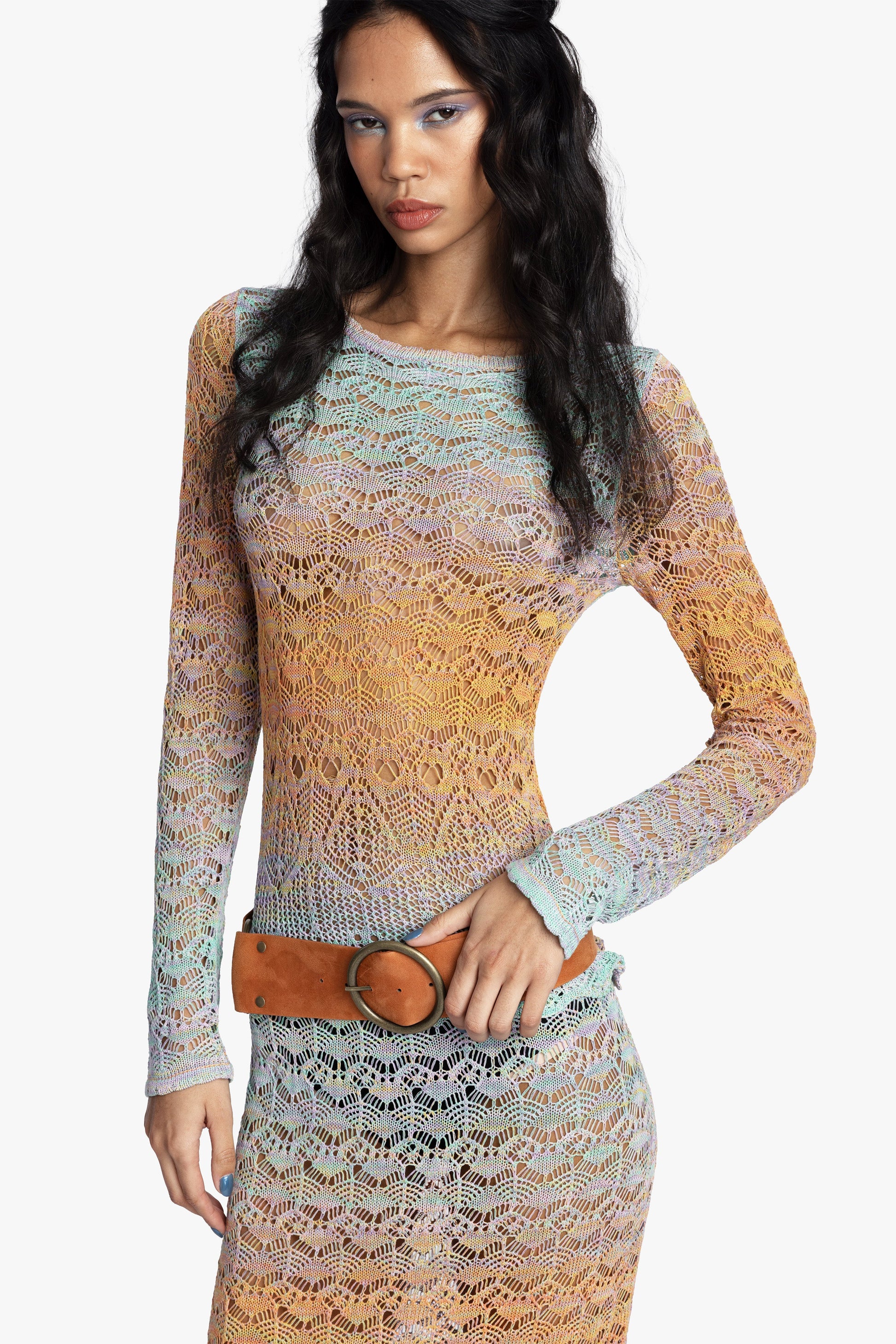 Woman wearing a long-sleeve crochet top with a gradient color pattern on a white background.