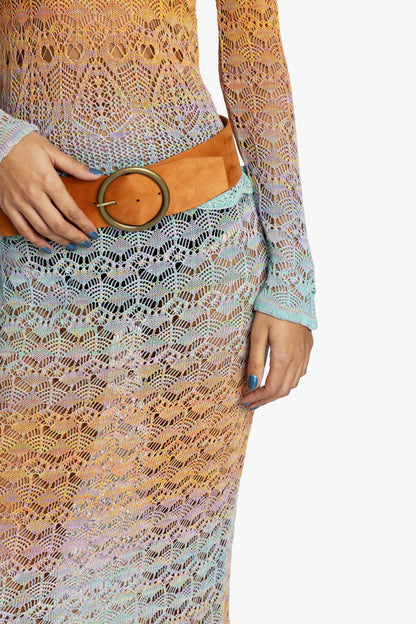 Person wearing a colorful gradient crochet outfit with a tan suede belt on a white background.