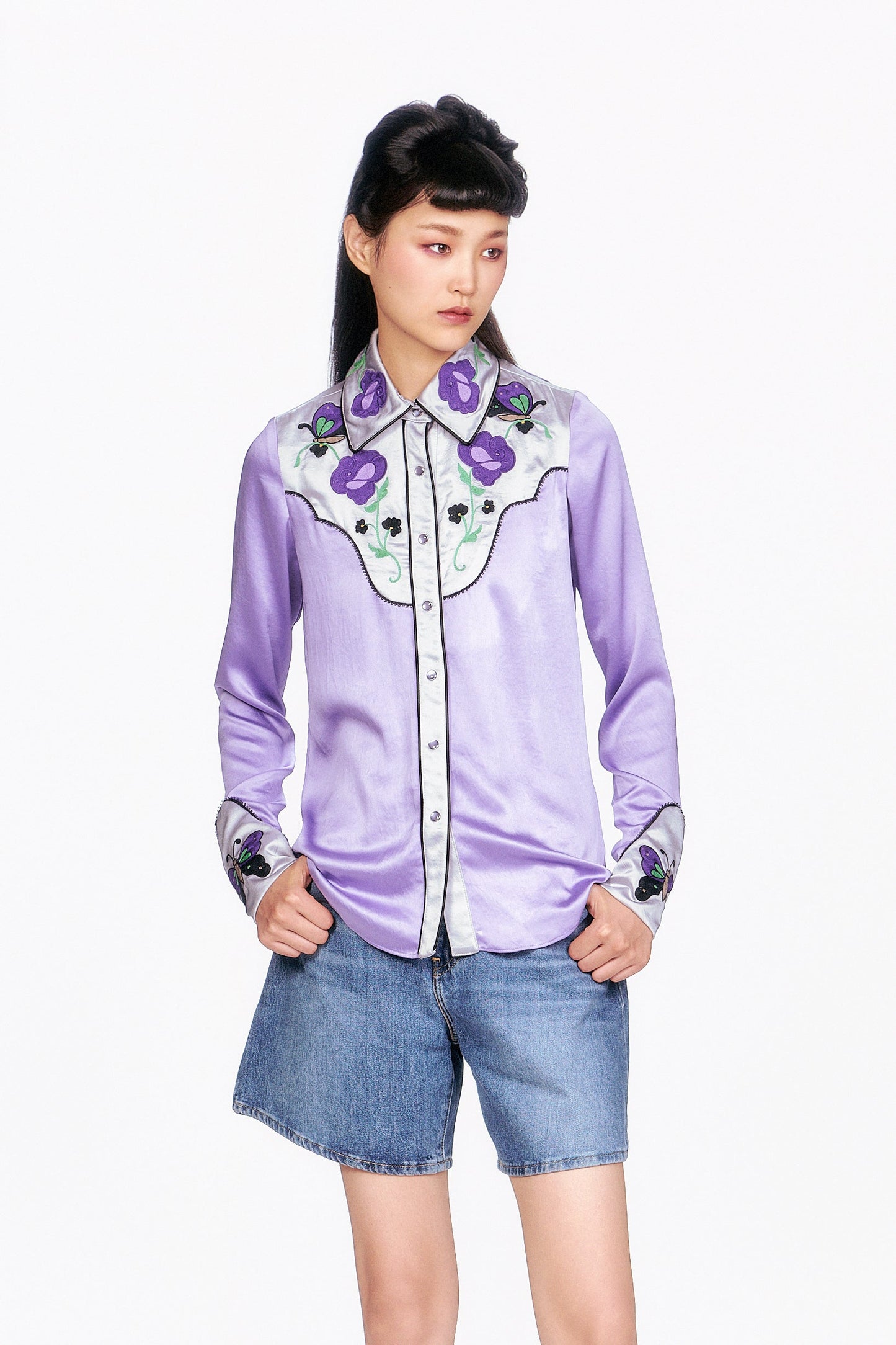 Woman wearing a purple Boudoir Satin Embroidered Cowboy Shirt and denim shorts