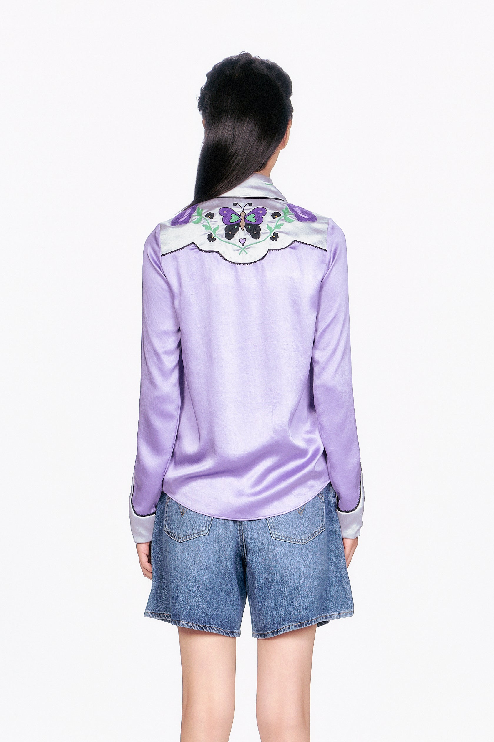 Woman wearing a Purple Boudoir Satin wavy Floral Embroidered on back shoulders and denim shorts.
