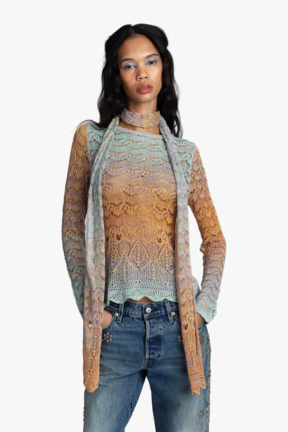 Women wearing a long sleeve gradient crochet top with matching long, thin scarf and jeans on a white background.