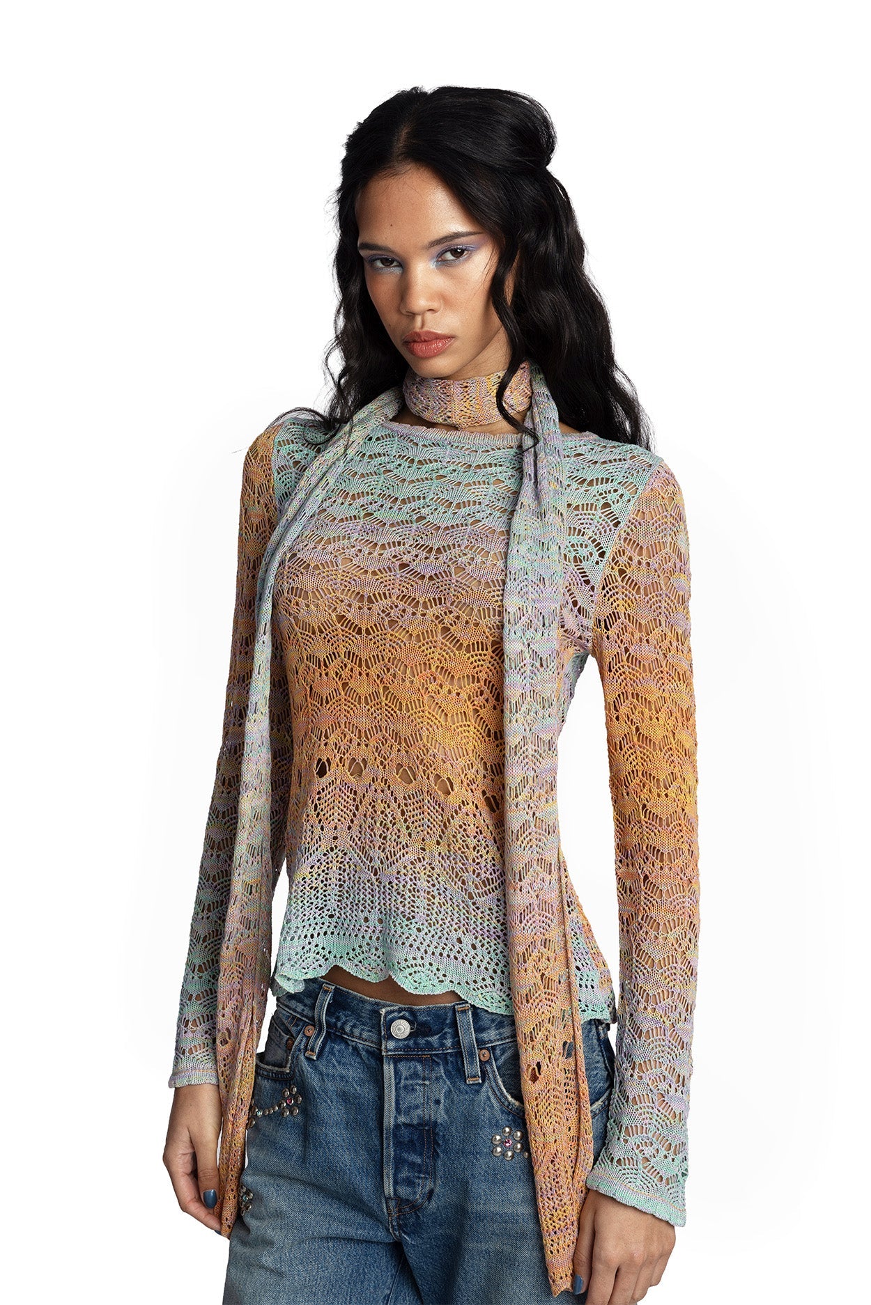 Women wearing a long sleeve gradient crochet top with matching long, thin scarf and jeans on a white background.