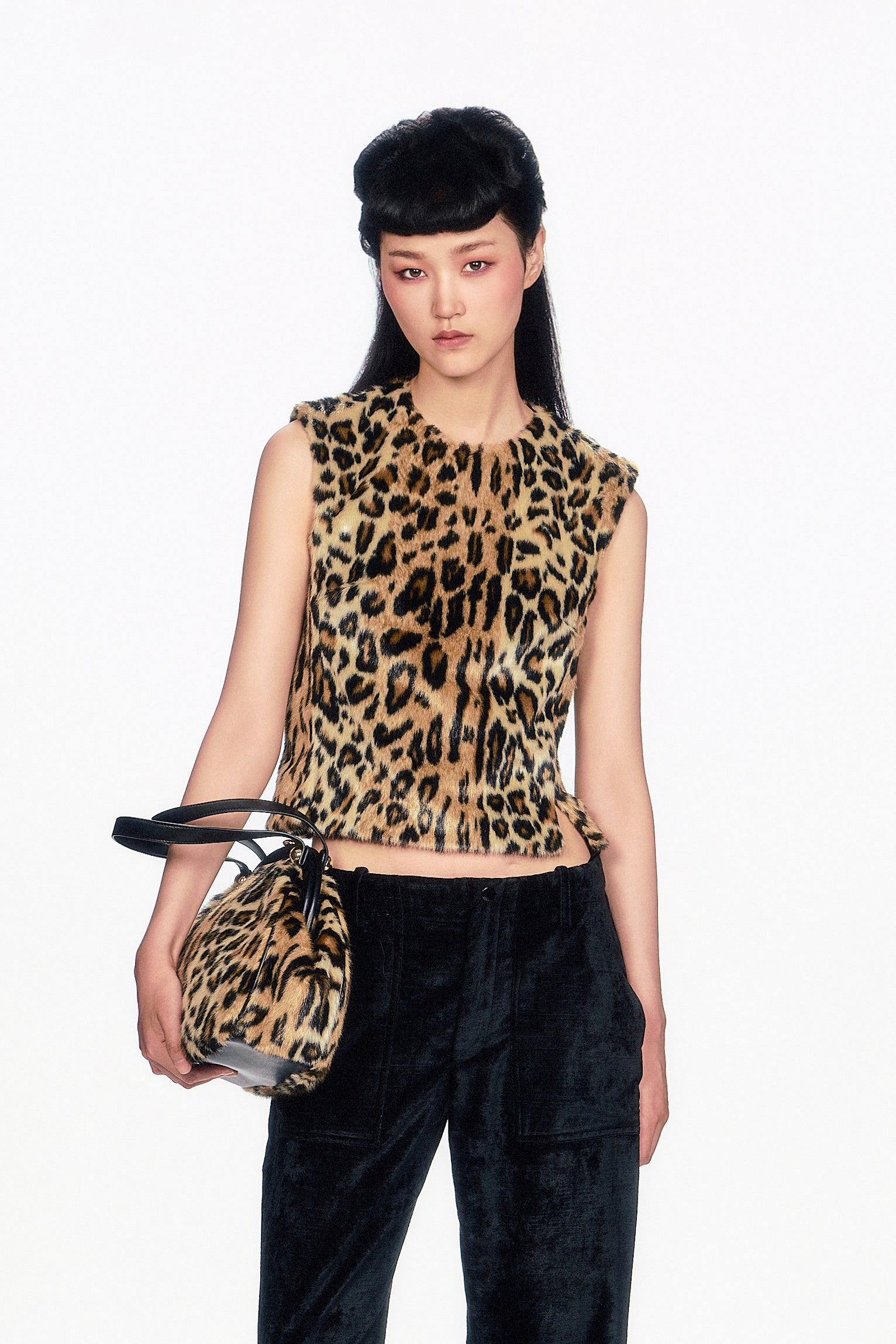 Model wearing a leopard sleeveless print top waist-long collar-line and holding a matching handbag