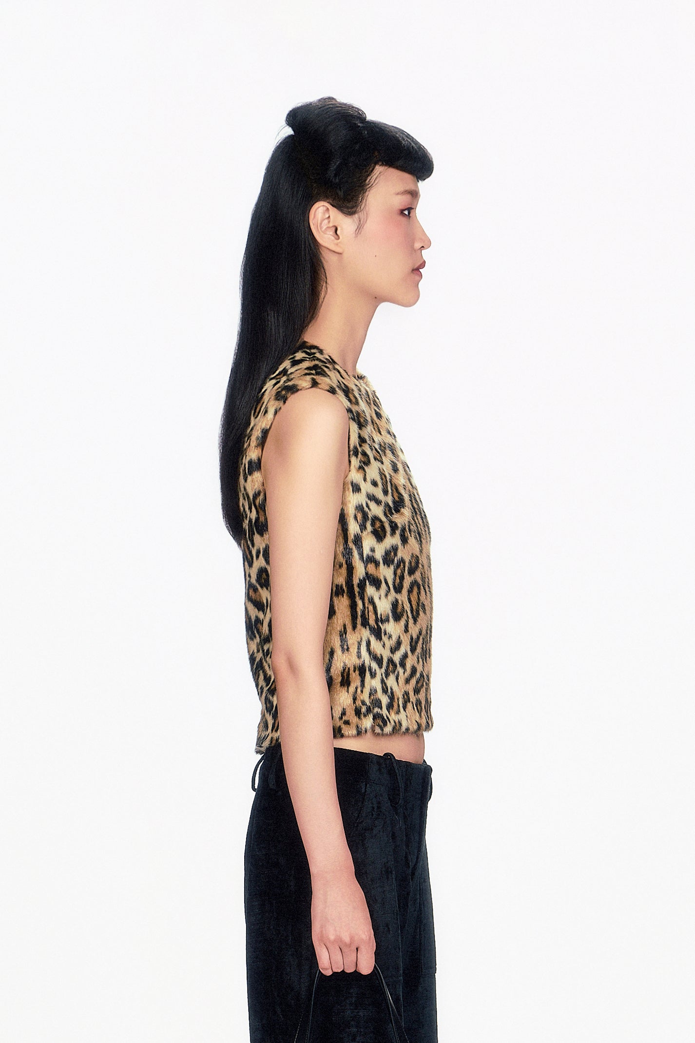 Woman wearing Faux Leopard Sleeveless Top, neckline collar and black pants.  