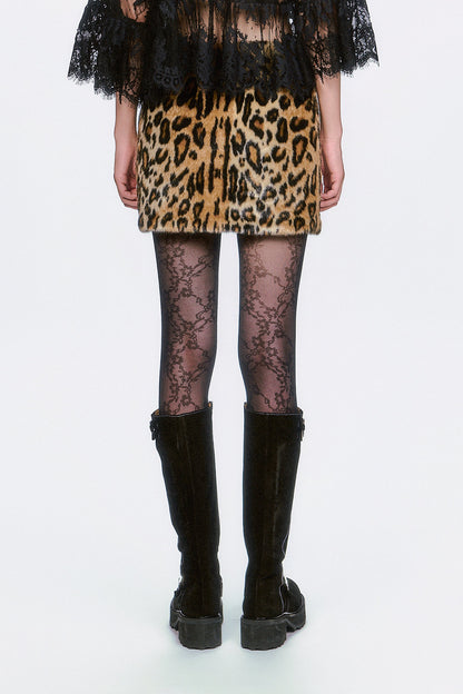 Woman wearing a Faux Leopard Mini Skirt, black lace top, and black knee-high boots. 