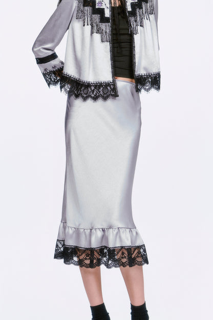 Boudoir Satin Beaded Fringe Bed Silver Jacket paired with a silver skirt, black socks and shoes.