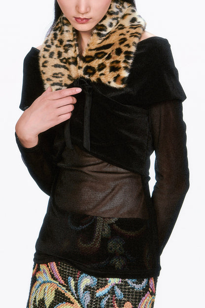 Woman wearing a black coat with a Faux Leopard V-cut Collar, large flaps, tied with black ribbon.