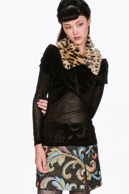 Woman wearing a black outfit with a Faux Leopard Collar and patterned skirt.