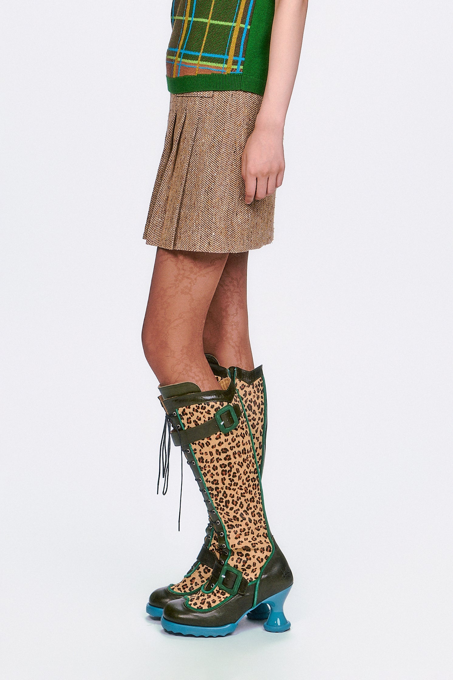 Person wearing The Herringbone Caramel Pleated Skirt & leopard print boots with green accents.