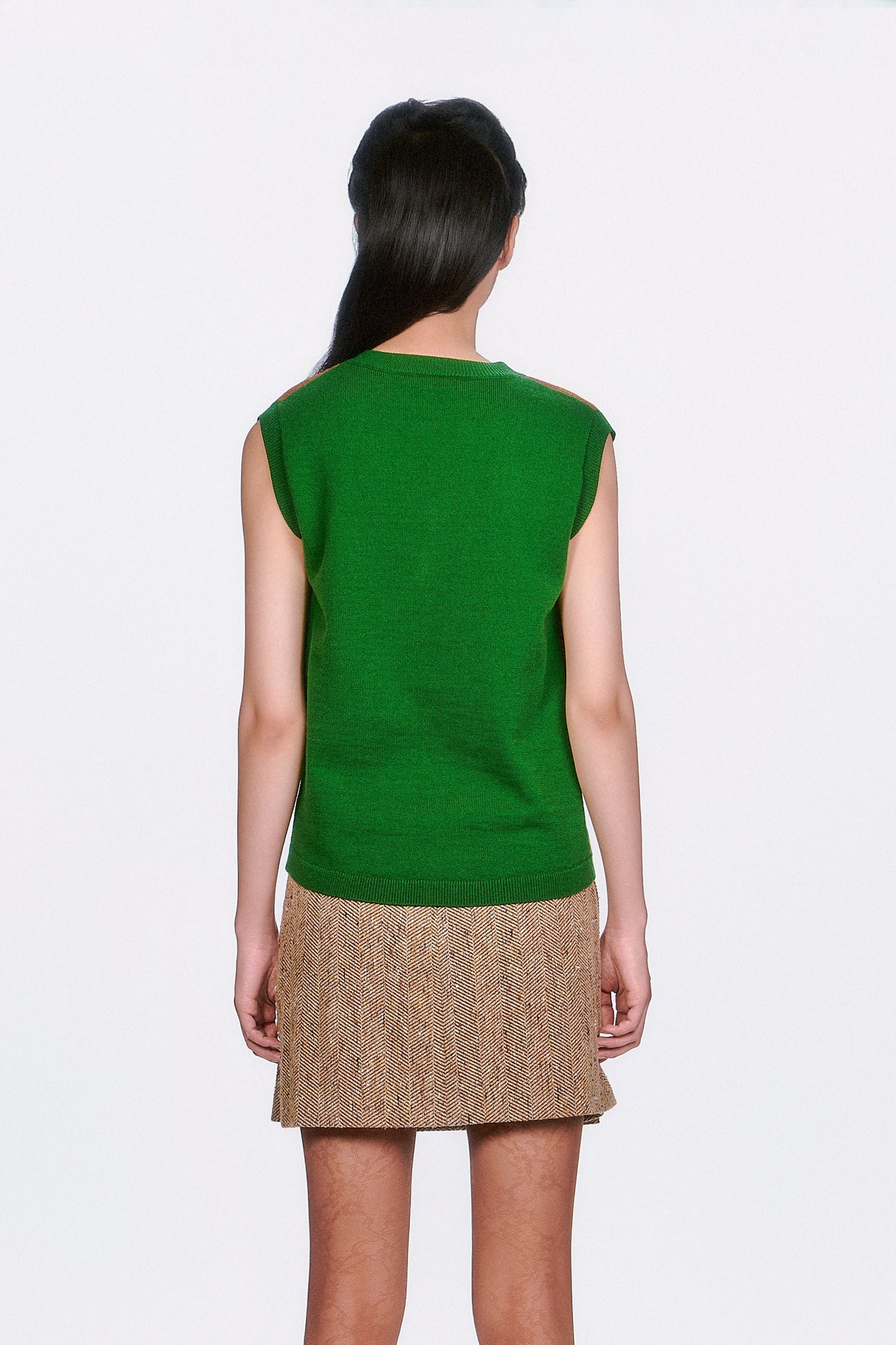 Person wearing a Plaid Sweater Vest Leaf Plain Green on the back, and beige skirt