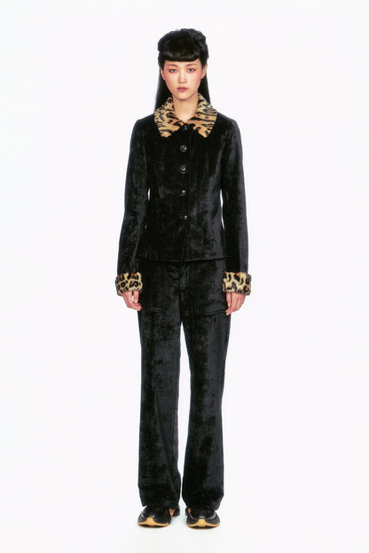 Person wearing a black velvet outfit with leopard print accents it a touch of sophistication and flair. 