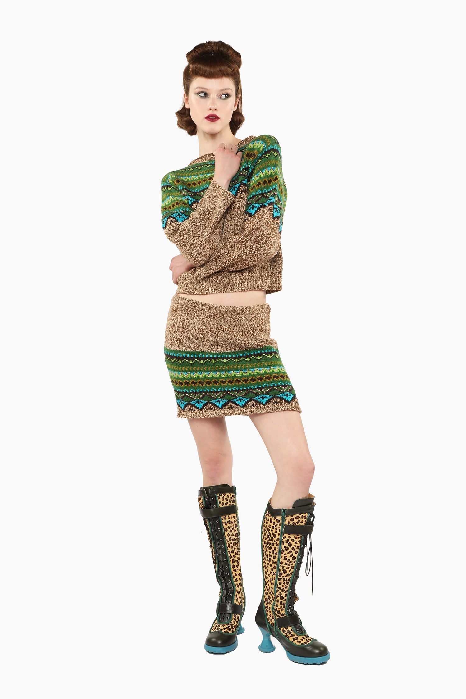 Woman wearing Fair Isle Sweater – Teal and matching skirt set with knee-high boots
