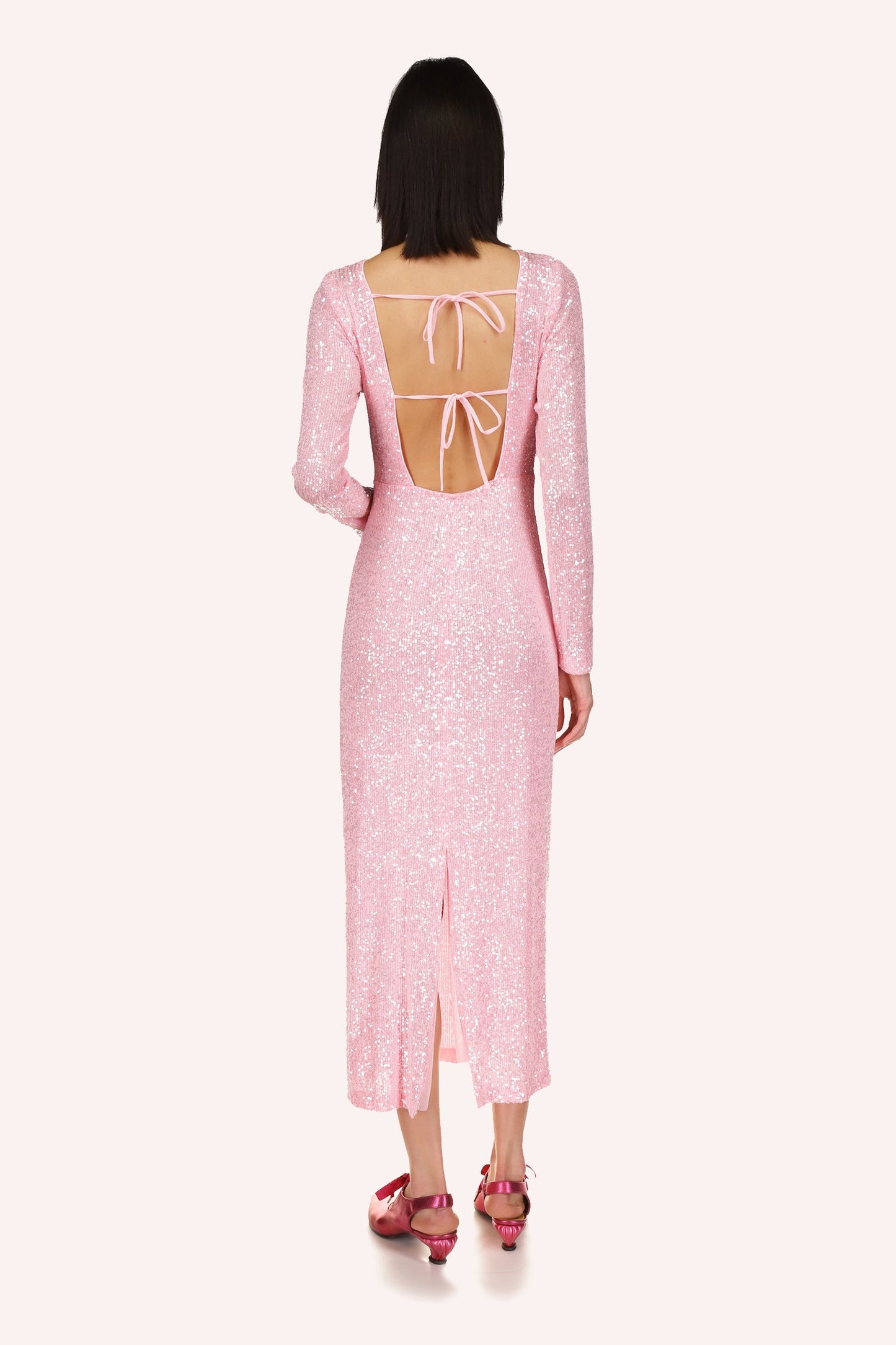 The dress reveals a nude back, 2-straps to secure it in place, slit at the bottom up to mid-legs