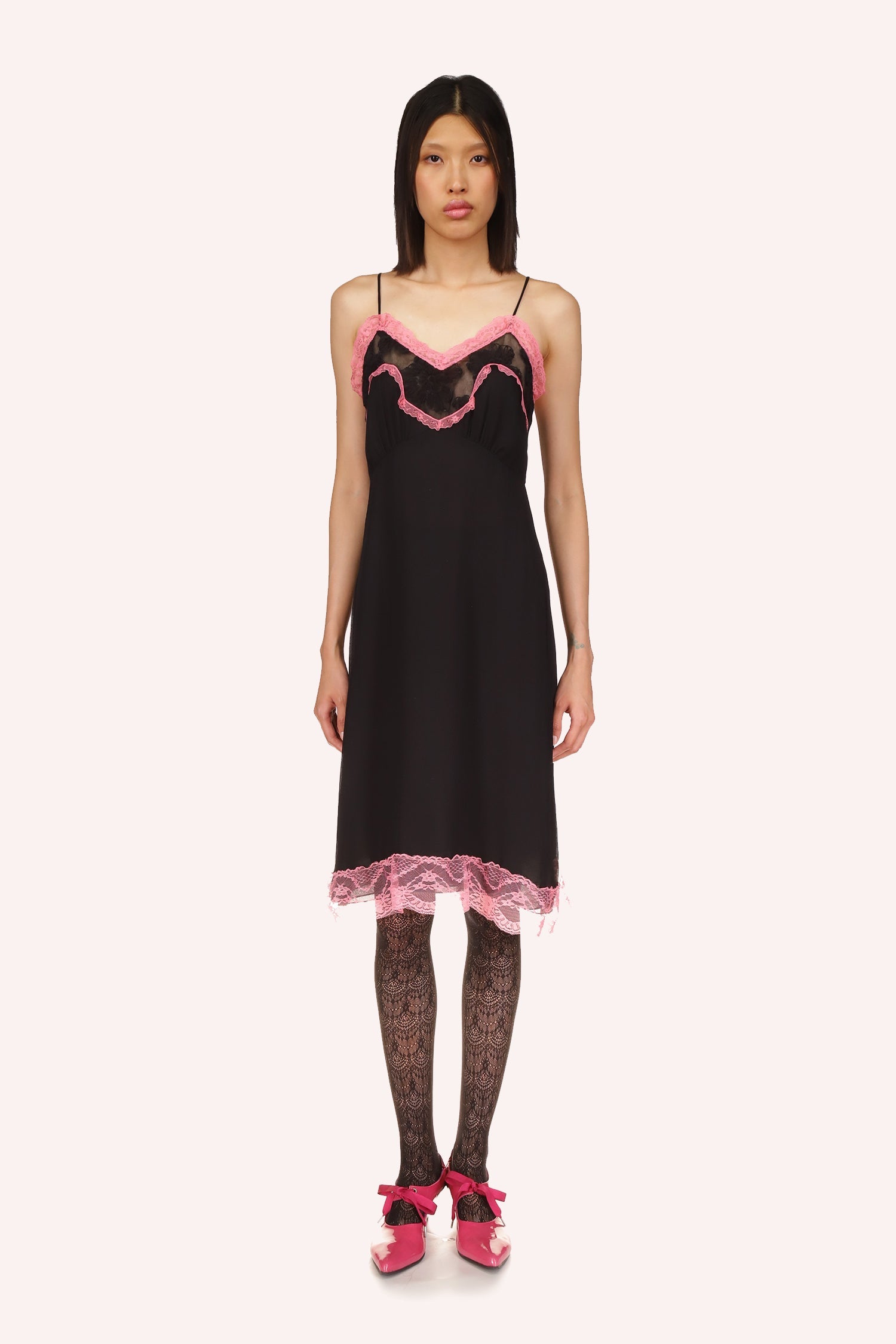 Black dress, pink rim provides pop of color, a black floral see-through between the pink, sleeveless, 2 straps, knee-long