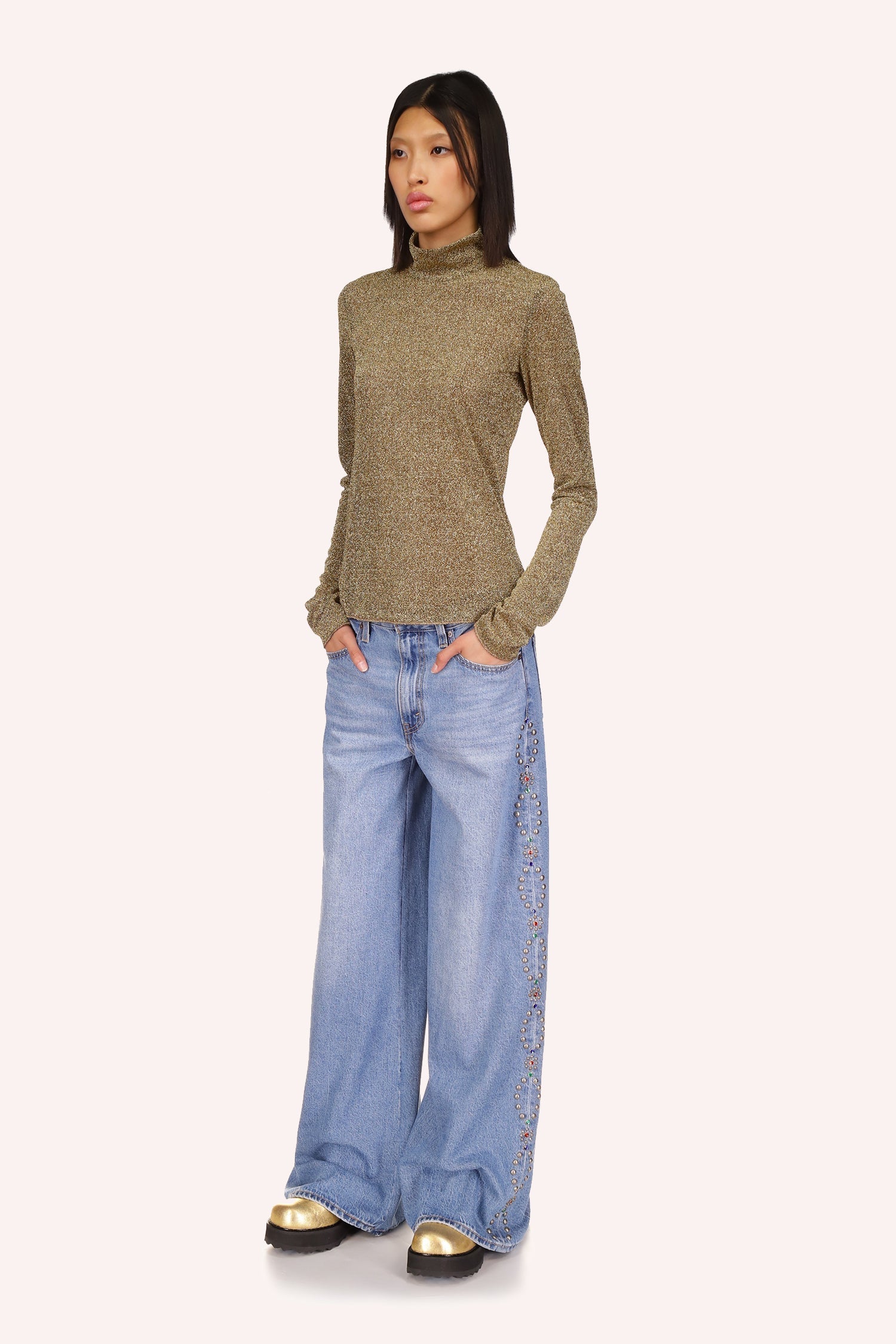 Sparkling gold color and turtleneck. Features very long sleeves that can be worn over the hands
