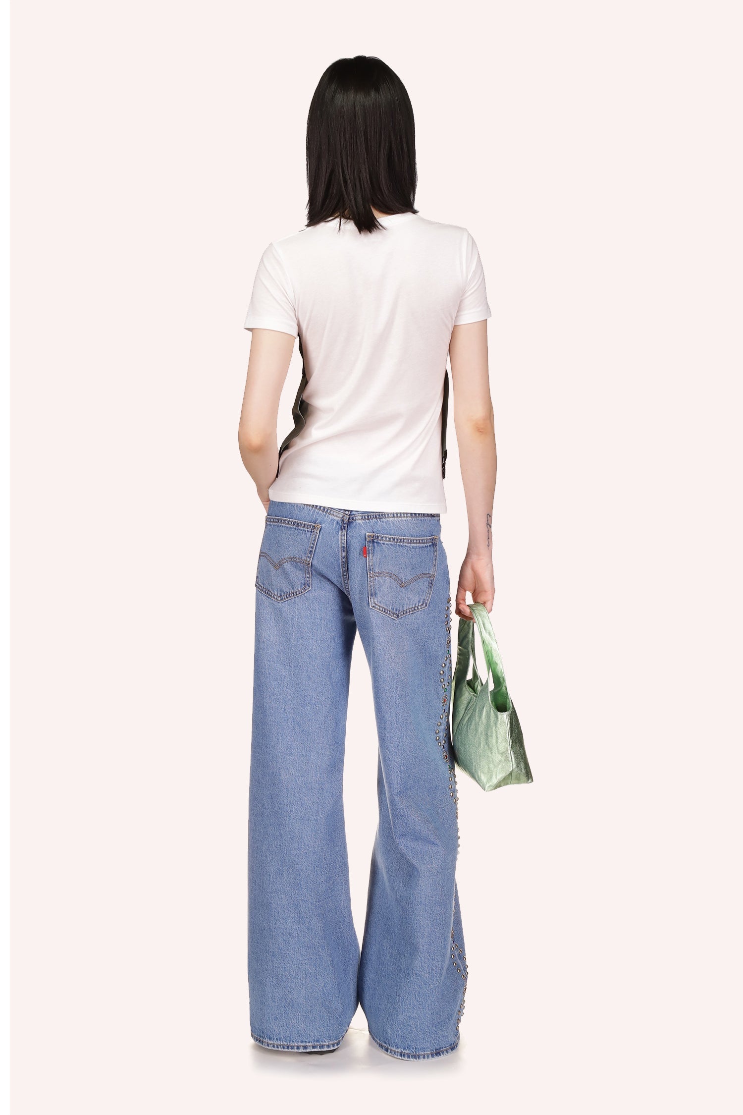Denim, 2 pockets back typical stiches, wide legs over shoes, oval studded shapes silver/copper