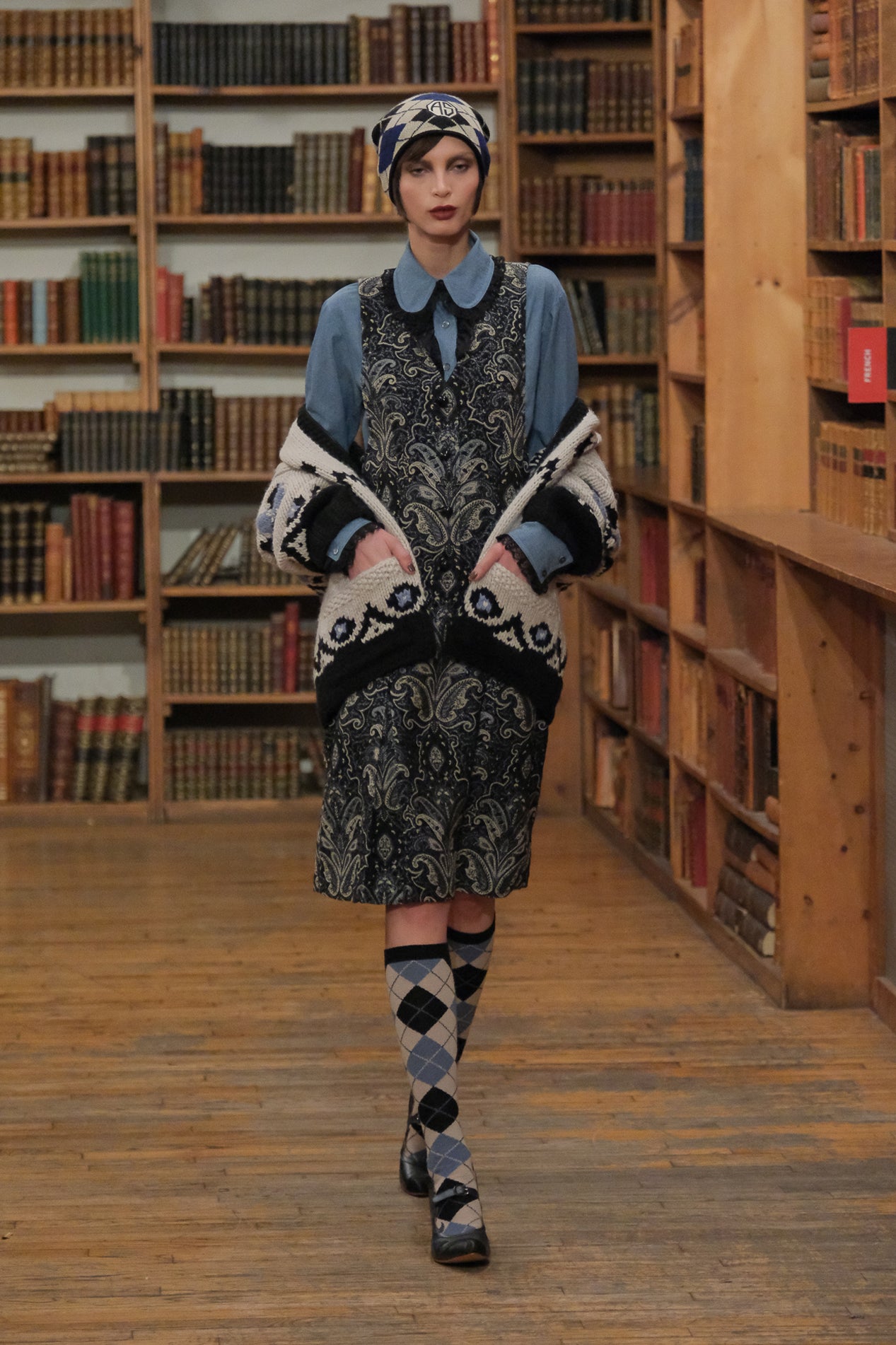 In a library, Tapestry Dress black & gray floral design, paired with bluish attire