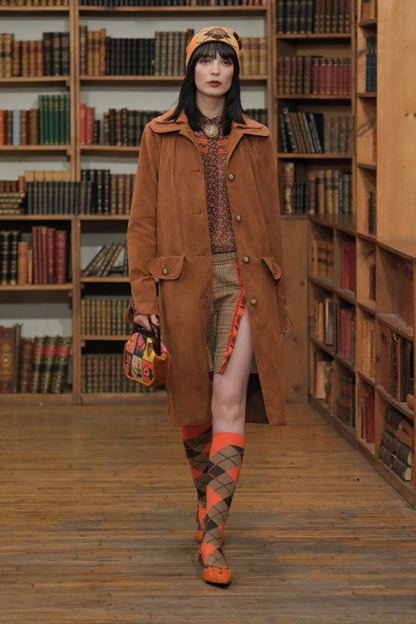 In a library, Needlepoint and Velveteen Cinnamon Purse, paired with fall attire