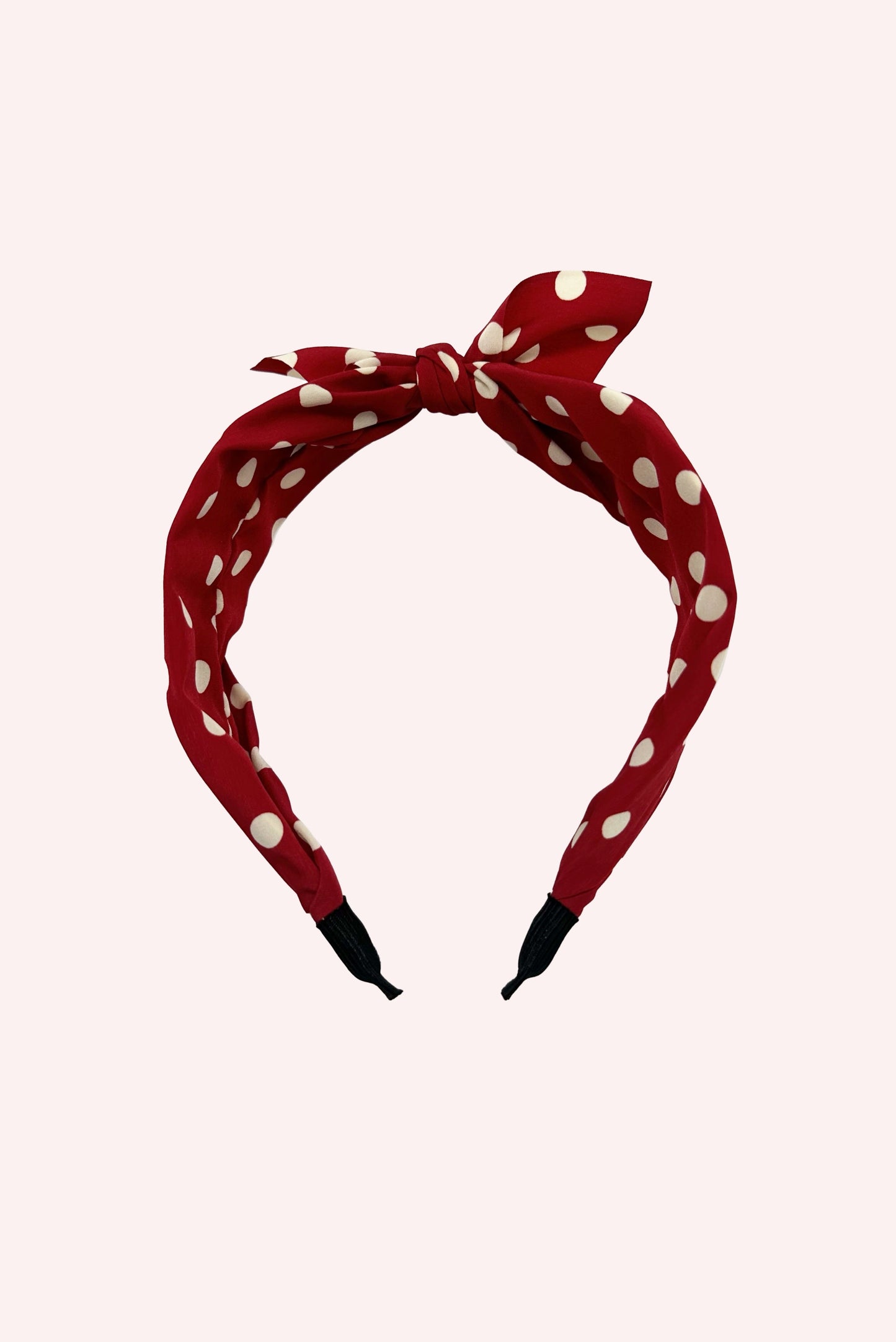 The Isabelle Headband, red base with white dots throughout. Knot at the center of the accessory