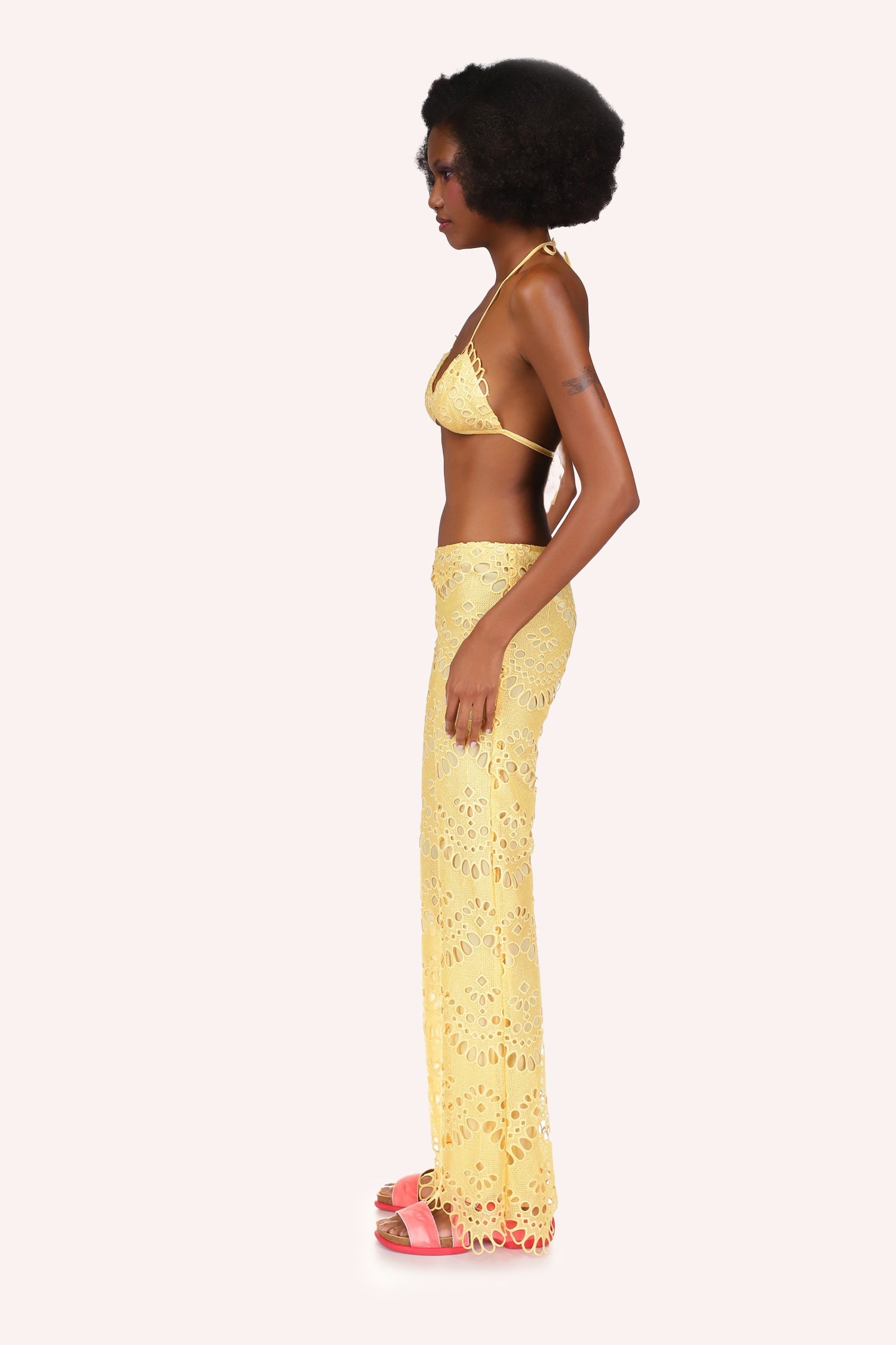 Eyelet Pants yellow with oval eyelets in a round shaped alignment, form-fitting on top