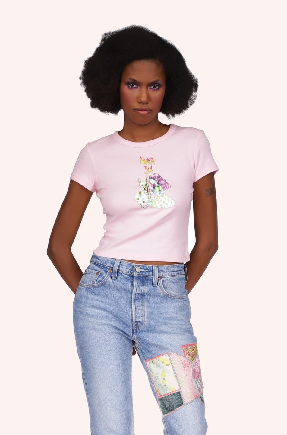 Micro Ribbed Baby Tee Light Pink, Short-sleeved, above the hips, Anna Sui logo above a stylized little girl with a large white dog.