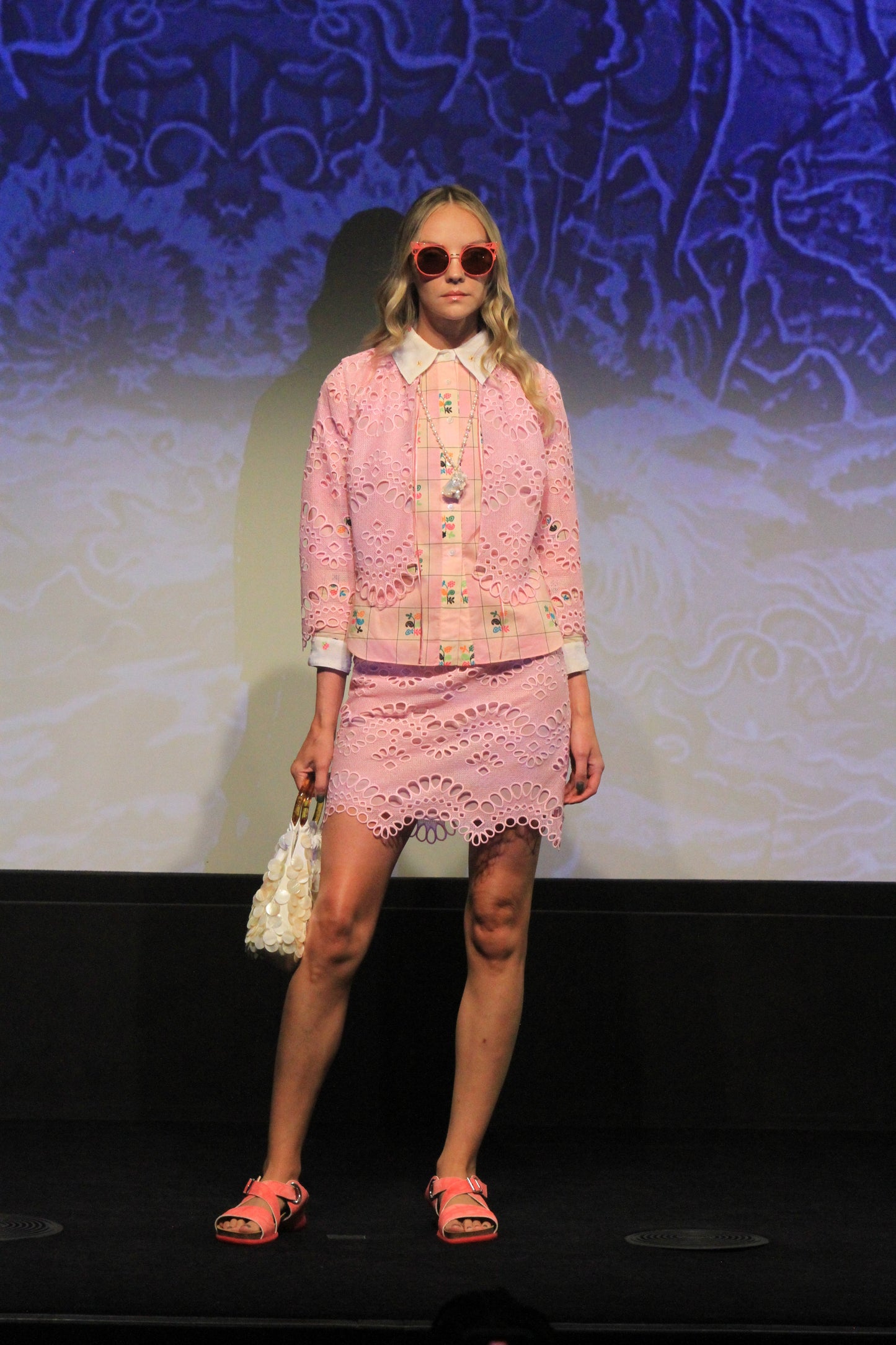 Under runway lights, Eyelet Jacket, pink with from small to large oval eyelets, wavy bottom hem
