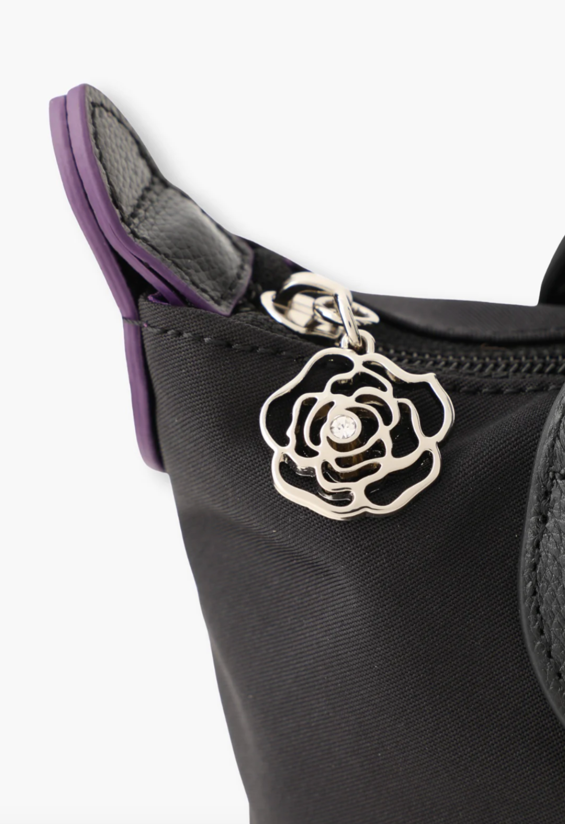 Detail of the zipper rose with a gemstone pull tab, horn with purple edges, and the black stiches 