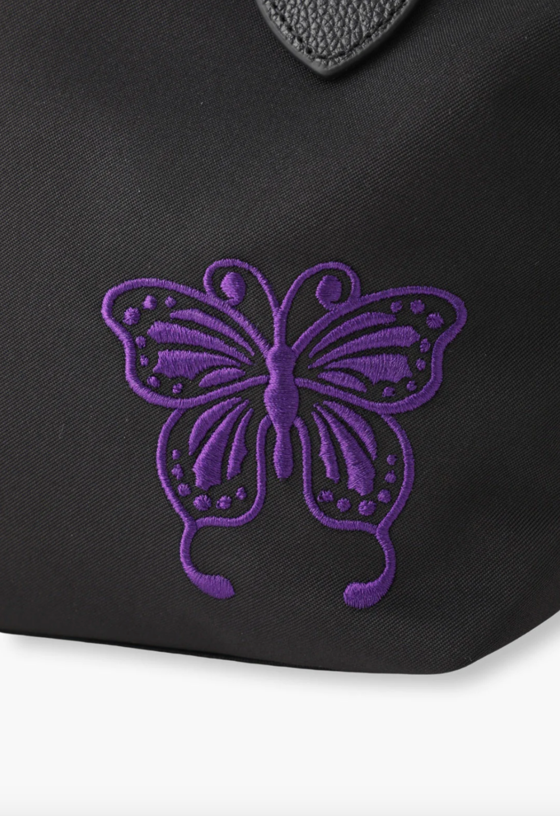 Small Voyage Tote black, Anna Sui purple embroidered Butterfly signature bottom right of the bag