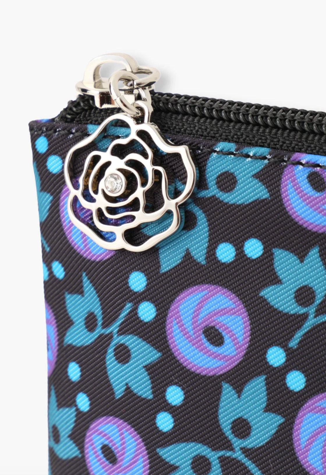 Detail of blue floral pouch and is finished with a silver rose charm zipper closure