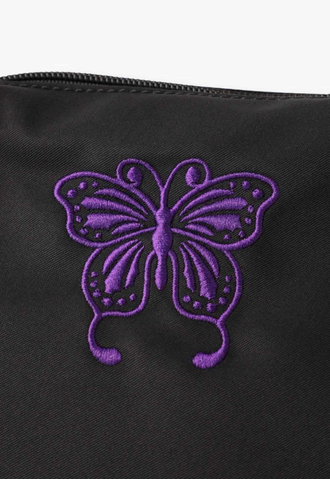Detail of  Anna Sui Butterfly embroidered in a purple color at the top of the bag