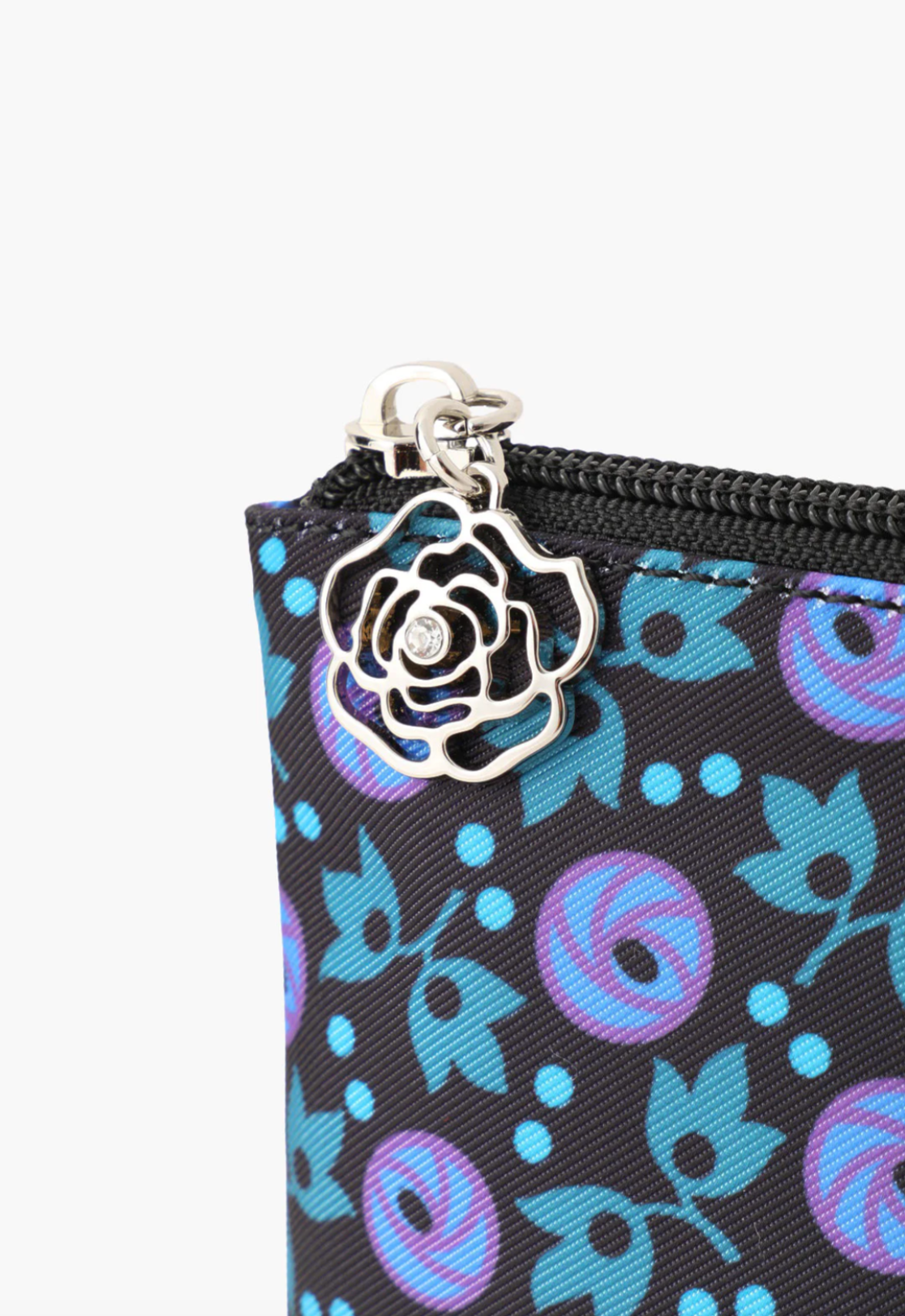 Detail of blue floral pouch and is finished with a silver rose charm zipper closure
