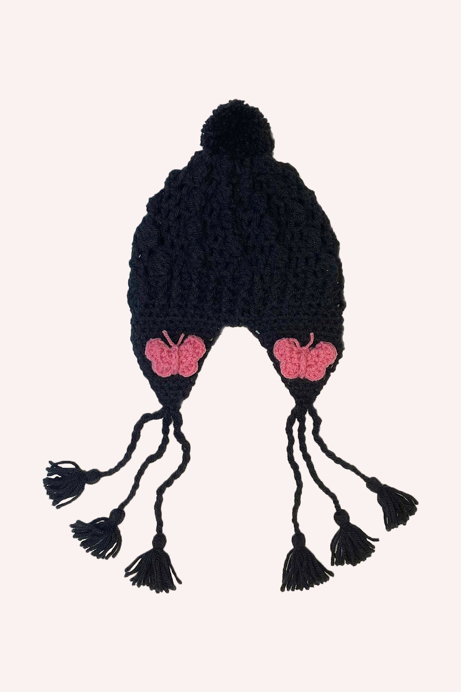 Black crochet hat with pom-pom and heart-shaped rose flaps, 3 strings on each side, and bobbles at the end