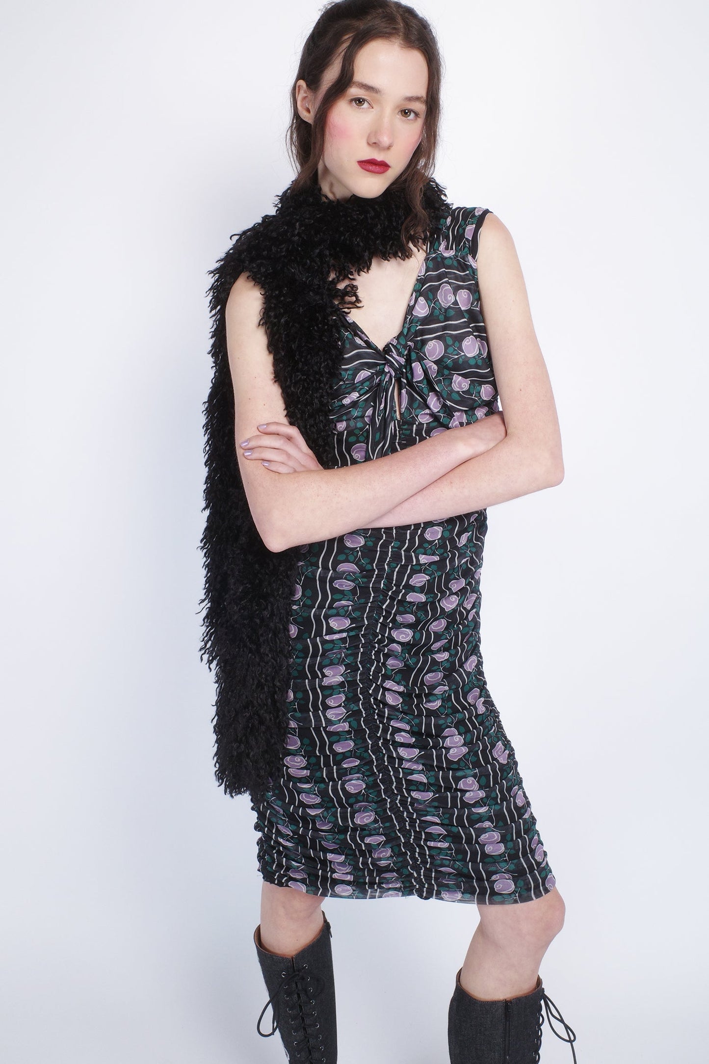 Woman wearing a patterned dress with a Faux Fur Scarf - Black and knee-high boots. 