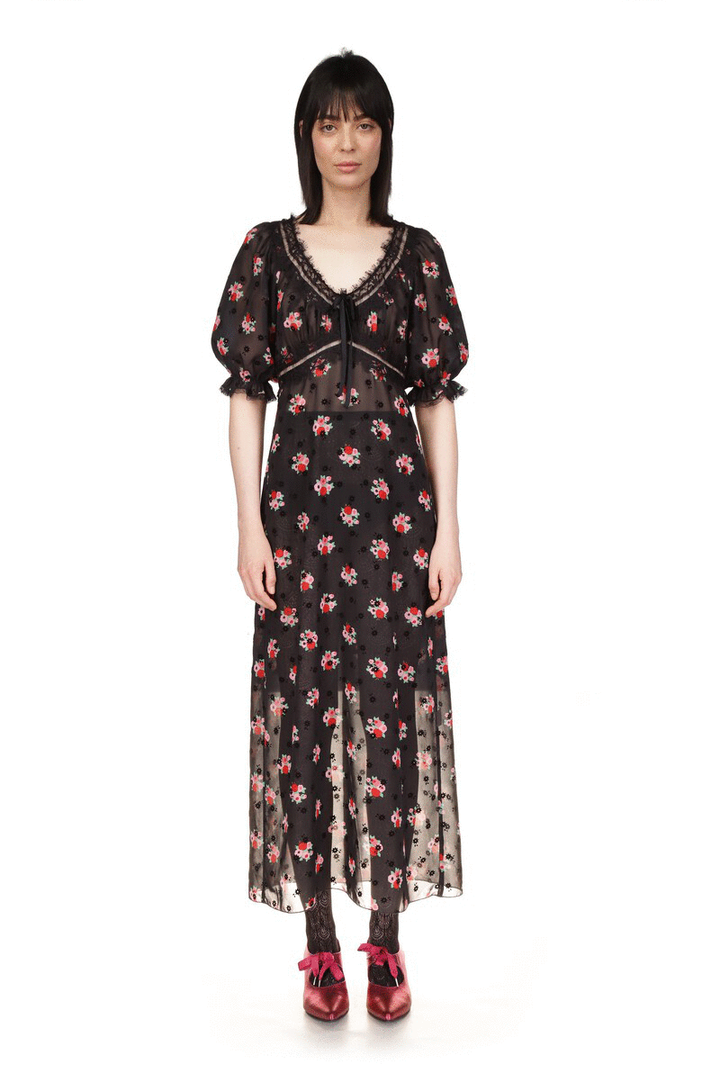 The dress is black with the Rosie Posie bouquet pattern, has a V-neck cut and elbow-length sleeves