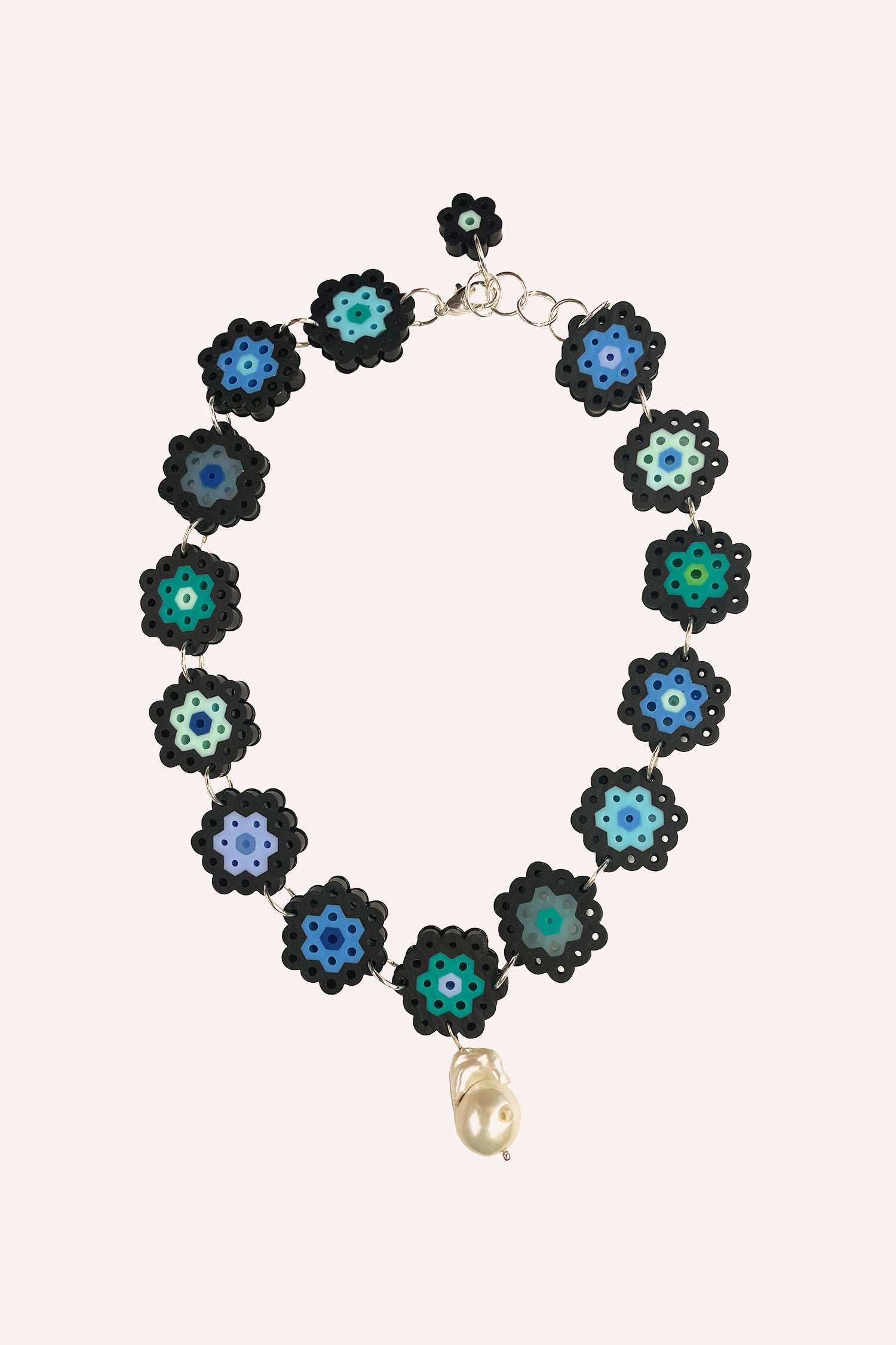 The Daisy Chain Single Pearl Choker in Teal features 14 daisy-like beads linked together with a chain and a pearl pendant