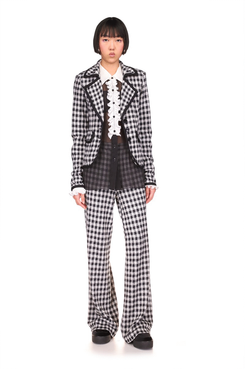 Checkered pattern in white and black, black highlighted seams, a wide collar with a V-shaped flap