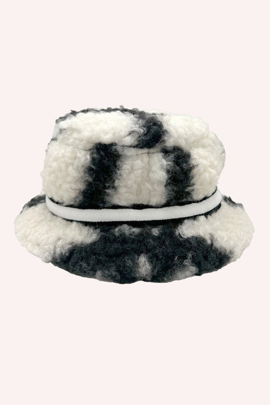 Cappello a secchiello in pelliccia sintetica nera, nera e bianca, con bordo bianco.