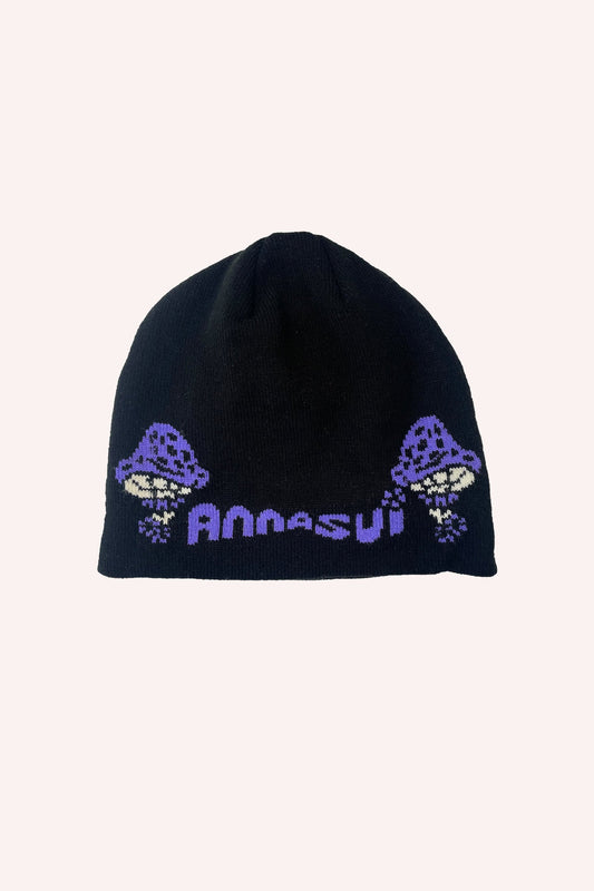 Black Beanie with is a large white and purple Anna Sui label between two large purple mushrooms