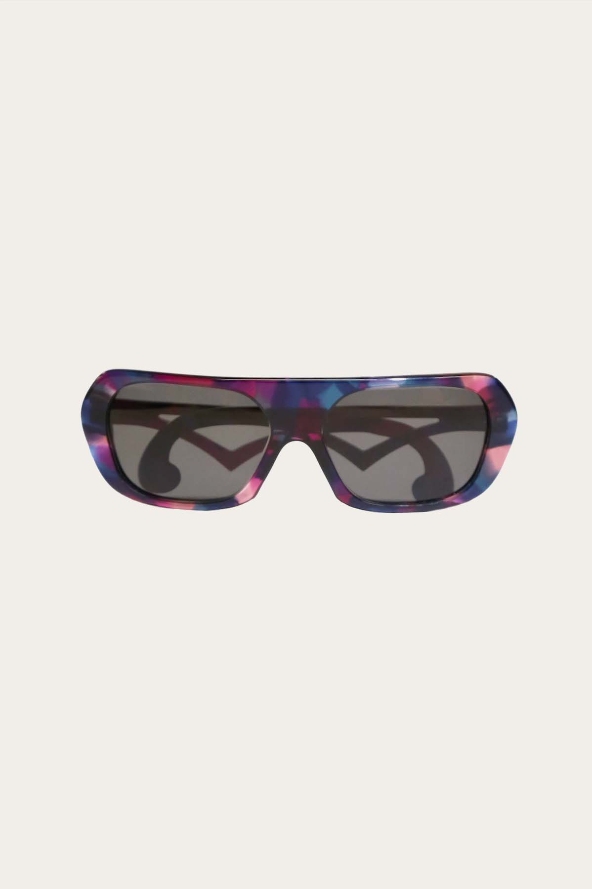Front of  Pink Blue Camo, large eyeglass frame with tinted lenses, branch with a V-Shaped design