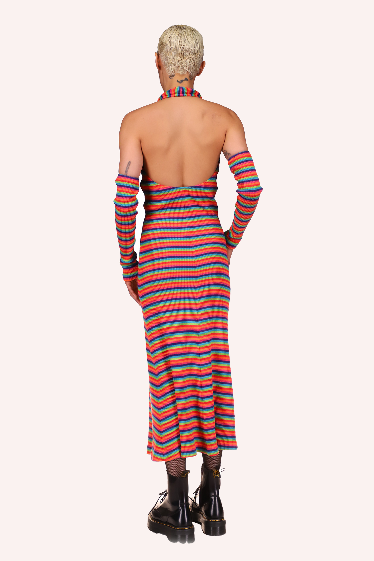 El vestido Rainbow Stripe Halter presenta un corte profundo en la espalda, largo a media pantorrilla y sin mangas