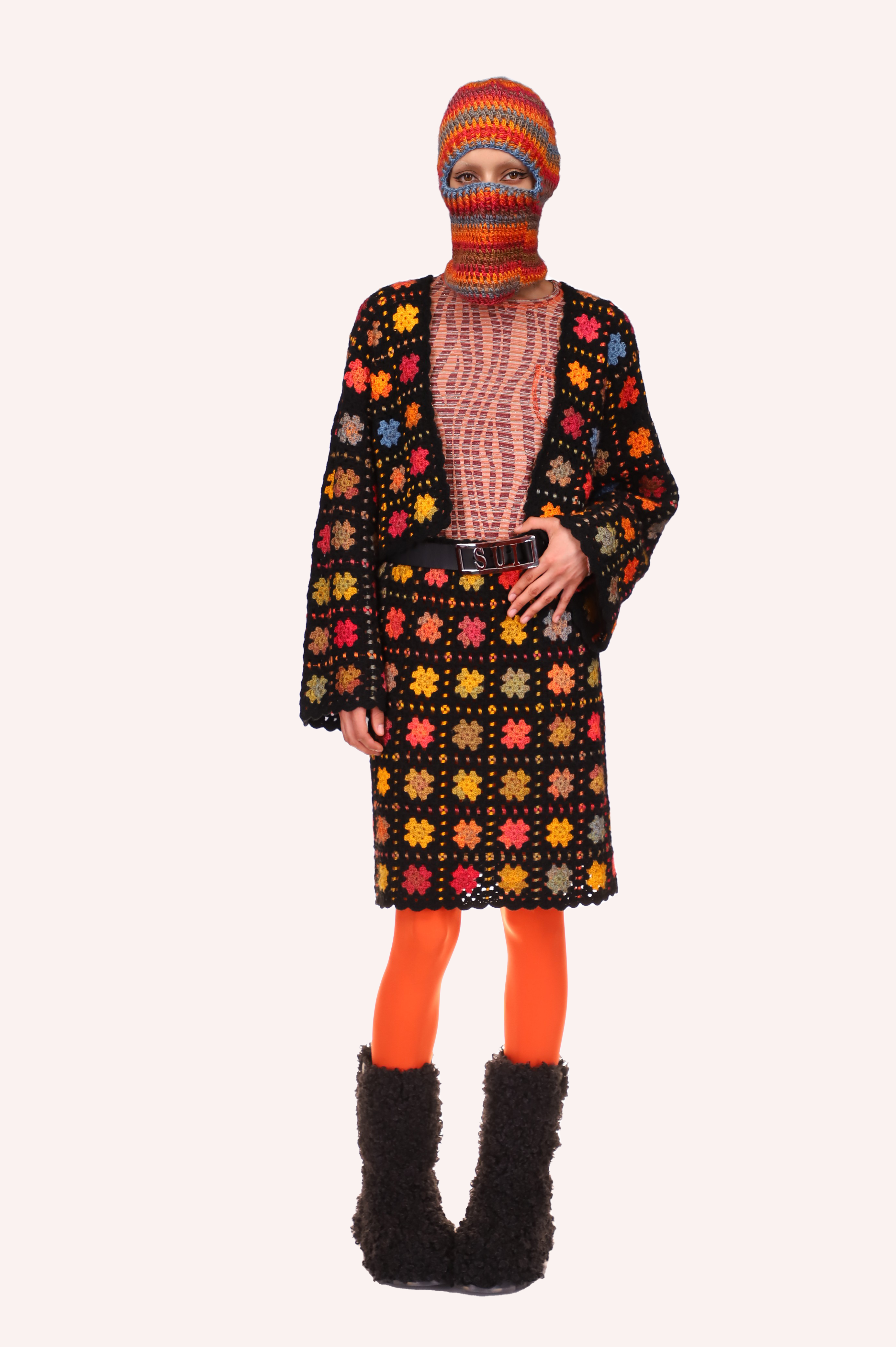 In squares of orange dots, stars like design are against a black background for the Stainglass Crochet Cardigan 