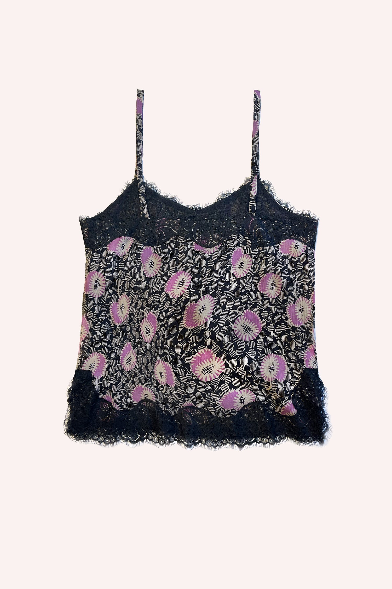 On a black background, white and pink flowers rest on grayish leaves, with black lace stitching accentuating the design